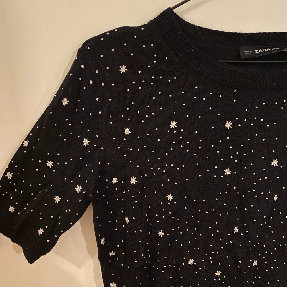 Svart T-shirt från Zara i väldigt finstickat material med stjärnor och glitter. Storlek M.. Toppar.