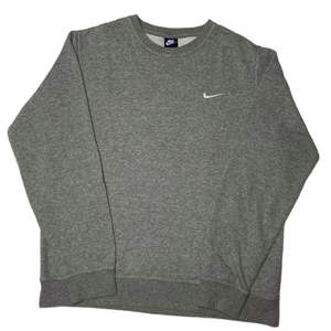 Grå sweatshirt från Nike. Skicket är 10/10 finns inga märken och känns som ny. Vintage look som passar det mesta! Storlek är S