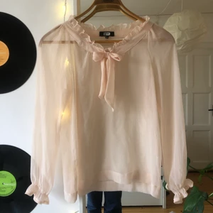 Genomskinligt blus - En ljusrosa, genomskinlig blus från bikbok. Söt ”volang” runt hals och handled och en rosett att knyta framtill. Kontakta gärna för fler bilder eller frågor