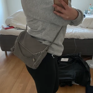 Stella McCartney väska  - Säljer min otroligt fina Stella McCartney väska. Modellen är ”Falabella” och är en axelremsväska. Säljes pga att den ej kommer till användning. Köptes på deras egna butik här i Stockholm. Dock finns inte kvitt kvar men dustbag och kort har jag sparat! förra köparen var oseriös därför lägger jag upp annons igen! Vill ha så smidig affär som möjligt då jag ska flytta och vill gärna bli av med den. Så sänkt priset till 2000kr. Inget prutande utan detta är fasta priset! ☺️