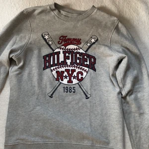 Tommy Hilfiger Collegetröja Strl 176 - En fin Tommy hilfiger Collegetröja i Strl 176. Den är använd endast ett ytterst fåtal tillfällen så i toppskick, nyskick & felfri. Nypris: 900kr