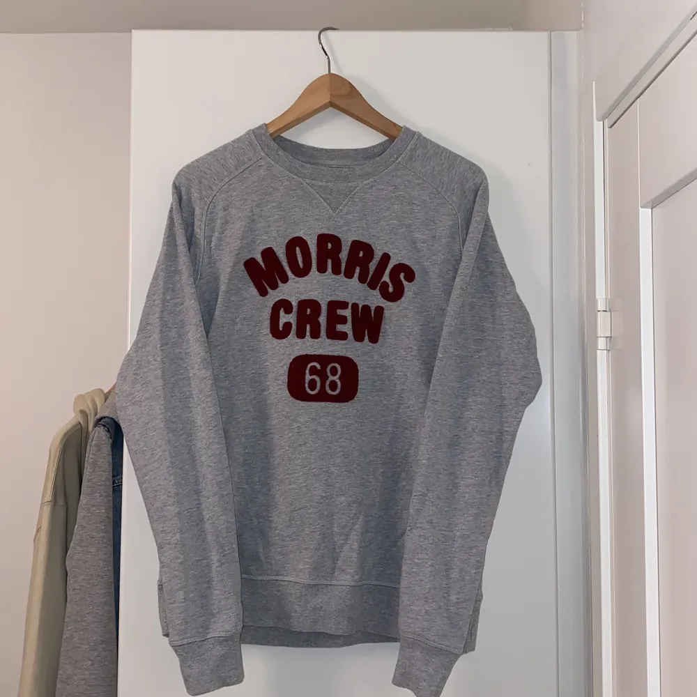 Morris sweatshirt i intil nytt skick, använd ett fåtal gånger och är som ny. Grå sweatshirt med ett rött bomullstryck. . Tröjor & Koftor.