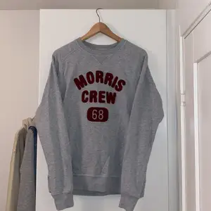 Morris sweatshirt i intil nytt skick, använd ett fåtal gånger och är som ny. Grå sweatshirt med ett rött bomullstryck. 