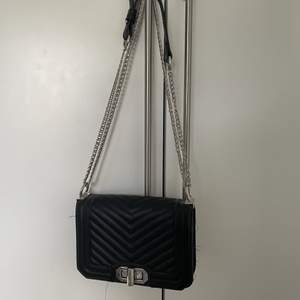En svart handväska med silver kedja 