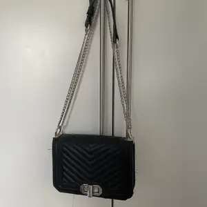 En svart handväska med silver kedja 