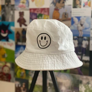 Vit buckethat med smiley - Kommer inte till användning därav säljes. I fint skick. Vet inte vart den är ifrån men bra material. Köp nu!