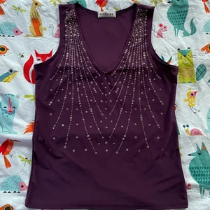 Vintage topp - Söt vintage topp med guld/silverdetaljer. Fin urringning och coolt mönster. Toppen är lila och i skönt material