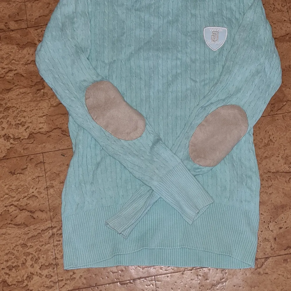 En blå långärmad tröja  från jacson den har armbågs förstärkning på båda armbågarna och inga skador . Hoodies.