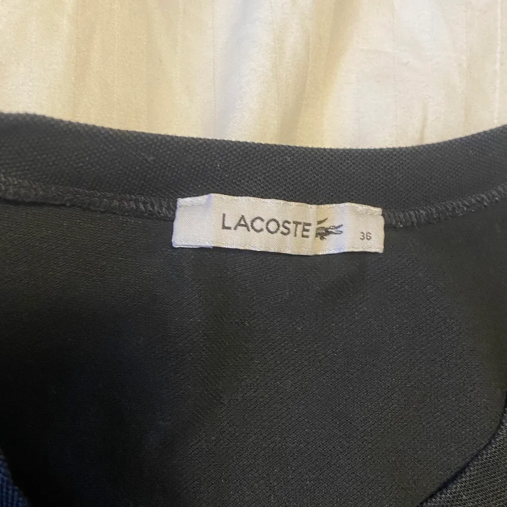 Jättesnygg svart Lacoste tröja med knappdetaljer.. T-shirts.