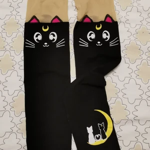 XS / S - Sailor Moon Kawaii Anime Tights - Jättesöta tights med Luna från Sailor Moon! Perfekt till konventet eller när man vill slå på extra charm med sin inre weeb! 🥰 Passar bäst på XS/S. Endast provade ett par gånger, men aldrig sett ljuset :') OBS! Det är de svarta jag säljer, sista bilden visar bara hur de kan se ut på!🐈