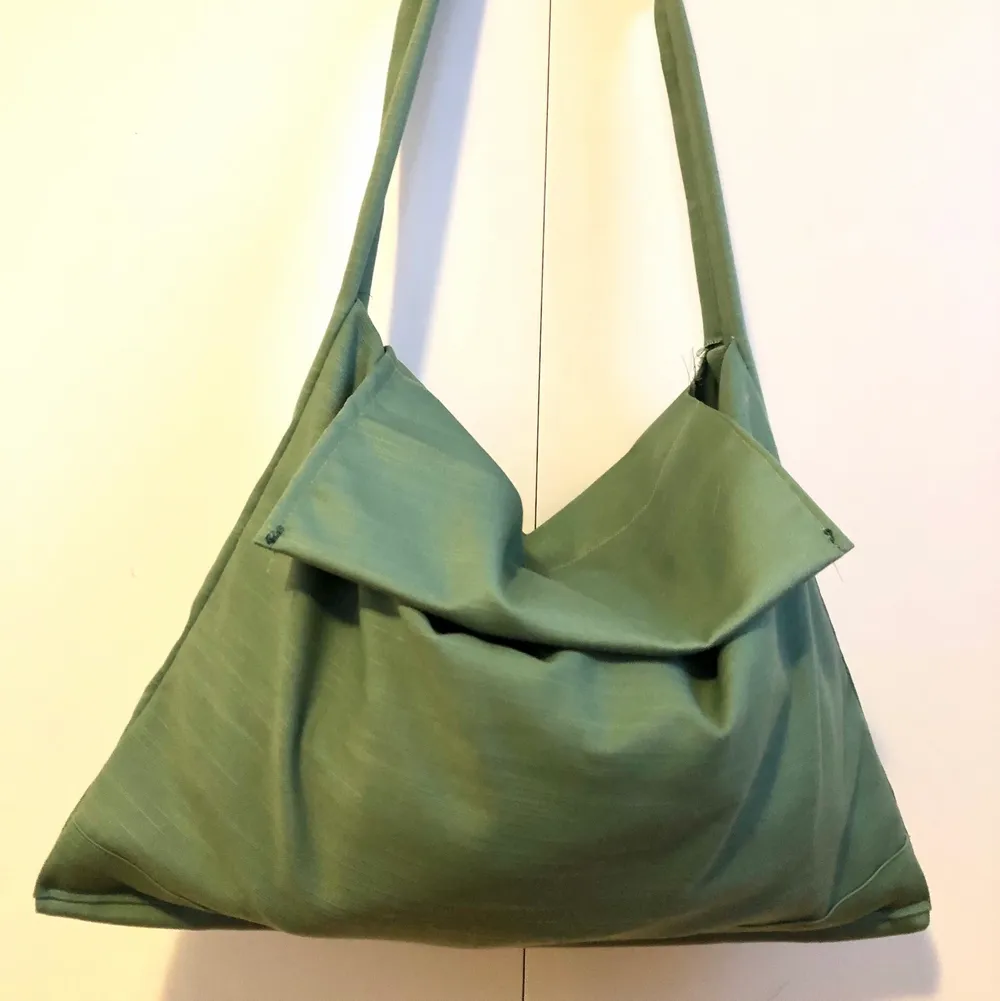 Säljer en egensydd enkel axelbandsväska i grönt glansigt tyg! Lite frakt tillkommer!🟢 Rymlig storlek . Väskor.