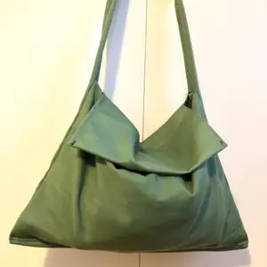 Säljer en egensydd enkel axelbandsväska i grönt glansigt tyg! Lite frakt tillkommer!🟢 Rymlig storlek 