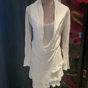 Vit omlottklänning - Superfin sommarklänning! Omlotten sitter fast, det är inget man knyter. En ”innerklänning och en ”ytterklänning” som sitter ihop med varandra. Har haft den ganska länge men den är i väldigt bra skick. 