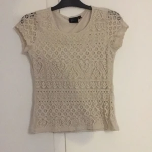 Tröja  - En tröja som beige med fina möster på. Andvänd ca 2 ggr. 