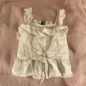 Linne med volanger  - Säljer detta linnet med volanger i en varmvit färg ifrån Vero Moda. Använd ett fåtal gånger. Har inte strykt det på bilden ☺️