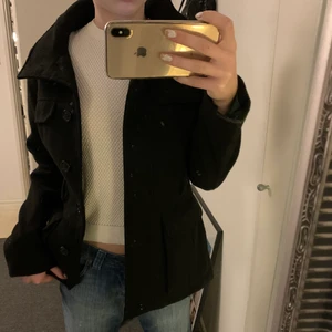 Kappa - Kappa med fickor i svart , får även med ett band om man vill ha med det