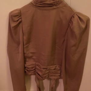 Gina tricot Blus - En classy blus med öppen rygg från Gina Tricot. Storlek 32. Endast använd 1 gång skicka gärna ett meddelande om du har frågor❤️‍🩹 (köparen står för frakten)