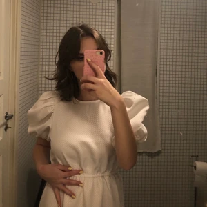 vit klänning med puffärmar  - en lång vit klänning med puffärmar från na-kd😍 endast använd en gång, men den revs upp på ena nederkanten, men det är lätt att sy ihop💕 på andra bilden ser ni hur lång den är på mig som är 165 och som vanligtvis har storlek S💛 köpt för ca 600