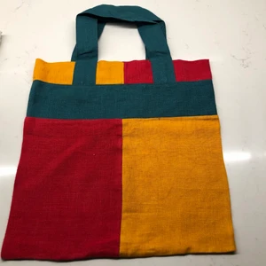 Tygkasse i återvunnet lin/ bomullstyg  - Tygkasse i overlock-sydda block i olika färger, i återvunnen textil. Handtagets höjd (från kassens kant) är ca 15,5 cm. Samfrakt är möjligt.