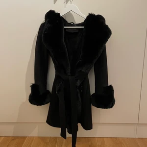 Svart kappa fuskpäls - Säljer denna fina svarta jacka/kappa med fuskpäls från Butik Garoff. Den är köpt för 999kr. Använd 2 gånger men säljer den eftersom den inte kommer till användning då jag fick en annan jacka i julklapp. Den är hel, fin och fräsch. Storlek M men den är liten i storlek så passar S, eller om man är mellan S/M. Möts endast upp!