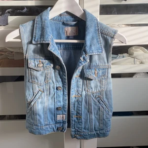 Jeansväst - Broken Arrows - Ljusblå jeansväst i gott skick, bara använts en gång. Storlek XS. / köparen står för frakt 