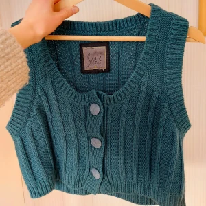 Grön väst - Grön något croppad väst med knappar. Står XL men passar mindre än så.