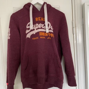 Superdry Hoodie  - Snygg hoodie från Superdry strl M men passar fler storlekar beroende på önskad passform. Bra skick. Spårbar frakt med DHL inräknad i priset!!