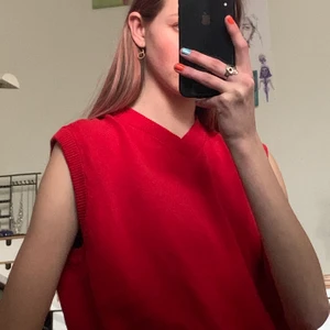 Röd stickad vest stl L - Väldigt fin och härlig stickad väst. Aldrig använd och fantastik kvalitet! 