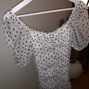 Prickig klänning med puffärm - Prickig tajt klänning från hm, aldrig använd. Väldigt stretchigt material, så blir väldigt fin figursydd klänning på.