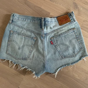 Levis 501jeansshorts  - Supersnygga jeansshorts ifrån Levis men som tyvärr är för stora för mig. Stilen är lite sliten och vintage vilket jag älskar! Dessa är Waist 27. (Säljer svarta likadana i Wais 28) Buda eller köp direkt för 250.