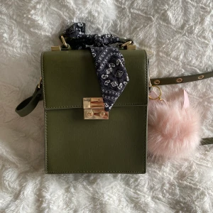 Axelremsväska  - En väldigt söt grön axelremsväska som endast använts 1 gång. Rosa bollen har jag själv satt dit så den medjöljs inte. Fraktkostnad tillkommer 🌸✨