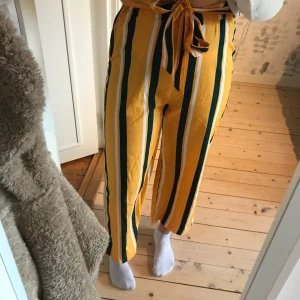 Byxor  - Byxor med ett snöre runt midjan. Gul,grön,vita byxor. Lite kortare i benen.