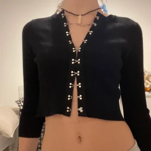 Hook n eye top  - Svart kofta/Top med coola knäpp detaljer. Köpt second hand, okänt märke men i jätte bra skick! 