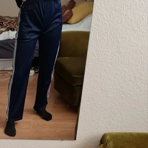 Vintage Adidas - Vintage adidasbyxor i mörkblått. Reglerbar i midjan och dragkedja på sidan av benen.