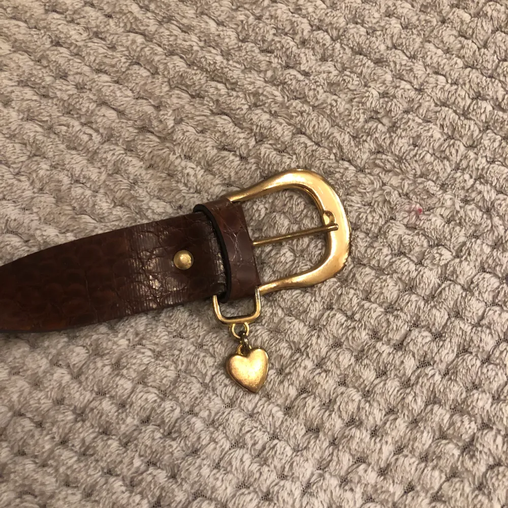 Vintage brunt läderskärp med hjärta✨❤️ hela bältet ee ca 90cm. 70cm till första hålet. Ca 83 cm till sista. Accessoarer.