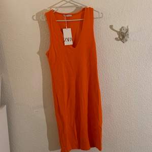 Utsökt tajt orange Zara klänning, säljs inte längre. Inte använd, lapp är fortfarande kvar. Väldigt vibrant färg med underbar urringning. Knälång klänning med töjbart tyg. Ordinarie pris 169.00 kr