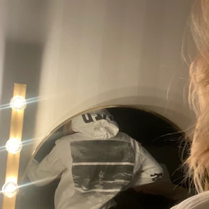 Hoddie med tryck - Hej! Säljer min vita hoddie med coolt tryck på baksidan samt tryckt text på huvan och runt vänsterarmen. Hoddien är i stl M i herr men tycker den passar bra på även XS/S/M beroende på hur löst man vill ha den. Jag själv tycker den sitter bra på mig som är S