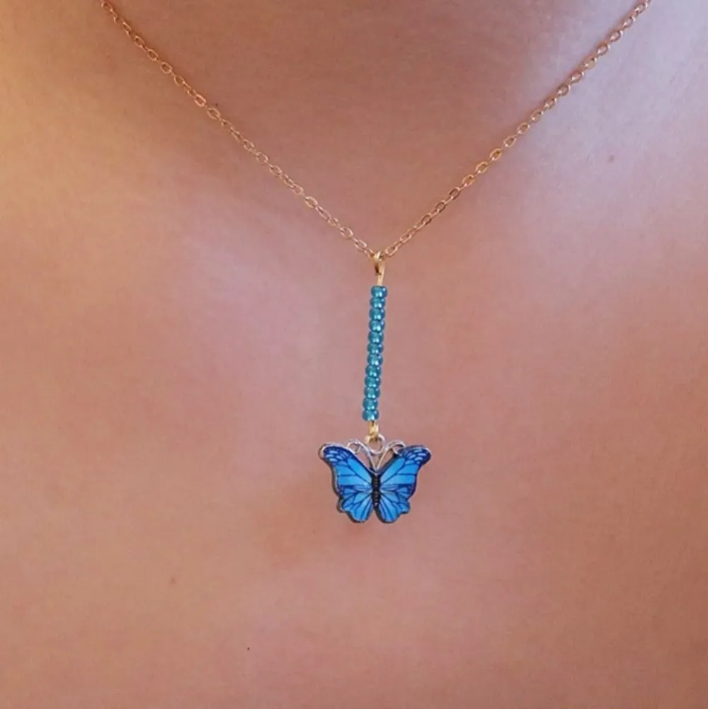 Handgjort halsband med blå sea beeds pärlor och en blå fjäril. Kedjan är 42cm lång. . Accessoarer.
