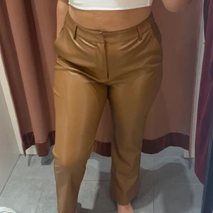 Bruna läderbyxor - Väldigt snygga, aningen vida kostymbyxor i skinn (imitation) inuti är de mjukt fodrade. Knappt använda Storlek 40 Sitter perfekt på mig i längden, är 165cm  Frakt tillkommer✨