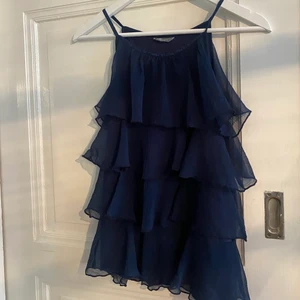 Topp - Jättefin marinblå volangtopp från Lindex barnavdelning. Strl 146/152, lite tajt vid bysten på mig som är en S men passar absolut en xs. Paljetter på axelbanden. Köparen står för frakten. 💙