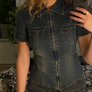 Jeans skjorta - Säljer denna riktigt coola jeans skjorta eller vad man ska kalla det❤️‍🔥❤️‍🔥 Älskar tyget, den har en väldigt vintage känsla över sig och sitter riktigt snyggt på kroppen då den är en aning figursydd:)) Detaljerna är riktigt snygga och gör den riktigt unik!! Har en matchande långkjol om man skulle vara intresserad att ha sättet då det ser ut som en klänning men det är riktigt snygg separat också! Skriv för fler bilder eller frågor, köparen står för frakt📦📦