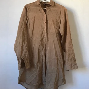 Beige randig skjortklänning, S, Melmelli - Superskönt skjortklänning eller längre skjorta från Melmelli. Beige mot brun, luftig och behaglig och knappar halvvägs. Förmodligen bomull. Märkt storlek S, men tror både XS och M fungerar utmärkt!  Skickas mot fraktkostnad eller hämtas i Stockholm! ✨🌸✨