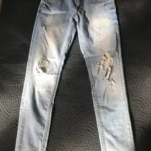 Enkla blåa jeans men lite slitningar här och där, slim fit från Rut & circle 