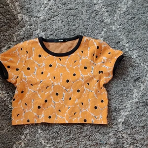 Bik Bok korttröja, Strl L - Inköpt för många år sedan men använd extremt sparsamt, max 2 gånger kanske. Något liten i storleken, borde passa någon med M bra. Mönstret är brandgula blommor och har kortare ärmar. 