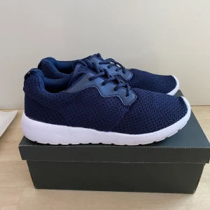 Marinblå skor i nyskick - Säljer dessa helt oanvända skorna från lager 157. Perfekta att ha till idrotten eller andra aktiviteter då man kanske inte vill smutsa ner sina dyrare skor.