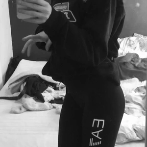 EA7 byxor - Ett par EA7 leggings svarta med vit text där det står EA7 Emporio Armani. Dom är äkta och köpa på Zalando för 700kr. Köpta för 1,5 år sedan ungefär! Använda 3-4 gånger💞 Kontakta för frågor osv, betalning sker genom swish❣️