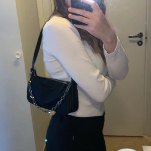 Axelremsväska med kedja  - En svart axelremsväska med kedjedetalj, näst intill oanvänd handväska där man får plats med det nödvändigaste 