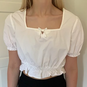 NAKD vit blus - Vit croppad blus från NAKD som var för liten för mig men som jag glömde skicka tillbaka så den är aldrig använd. Nyskick. Den är en storlek 40 men definitivt liten i storlek💕