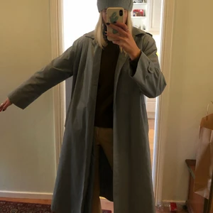 Trenchcoat köpt second hand - Säljer en sååå snygg trenchcoat som tyvärr inte kommer till så mycket användning, den är i fint skick och har en blå/grå färg!! 