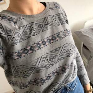 Crop top grey sweater with ethnic pattern.